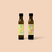 Two bottles of Indigearth lemon myrtle and finger lime flavored oils on a beige background