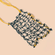 Net bag with yellow handle on a beige background